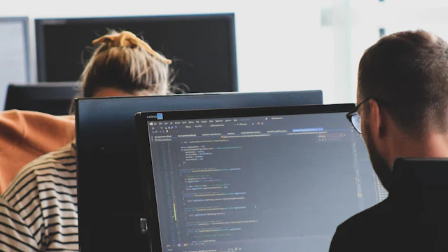 Developers writing code at their monitors