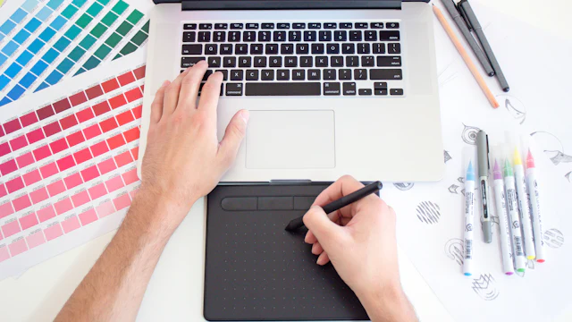 Designer working with a drawing tablet and colour swatches